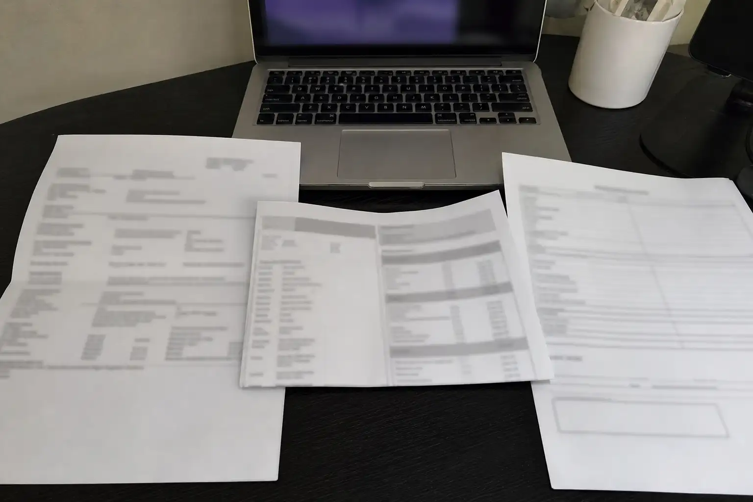 給与明細、EPF引き出し申請書、マレーシアの銀行通帳が机の上に置かれている